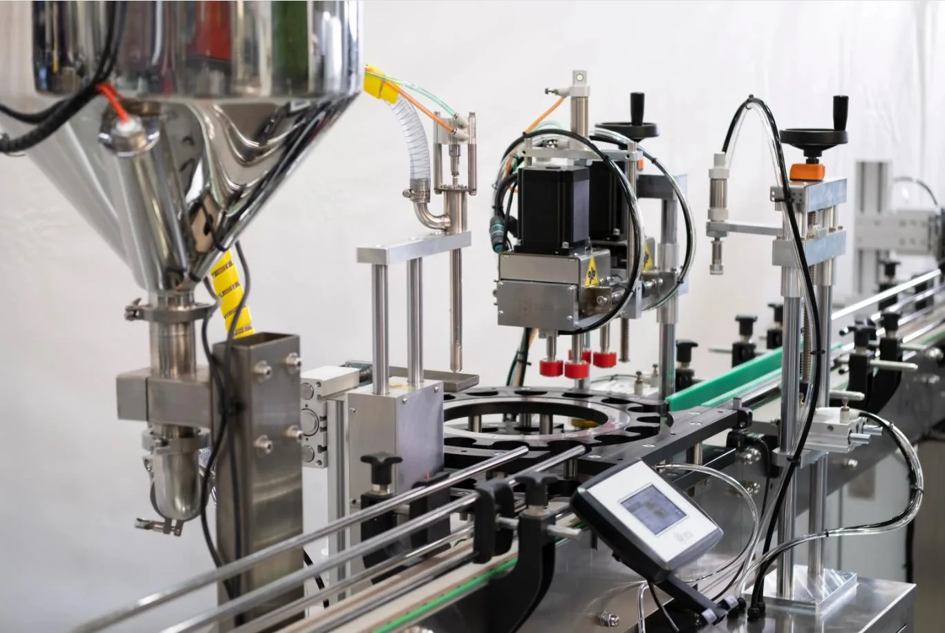 Filling line: doser, capping unit with caps and a guided conveyor ready for the marking station